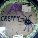 一张万圣节蛋糕的图片，上面装饰着一只蜘蛛，把“creepy”拼成“creppy”