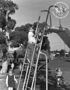 孩子爬上台阶的黑白照片幻灯片的一个公园,和一个模糊的身影长臂的距离