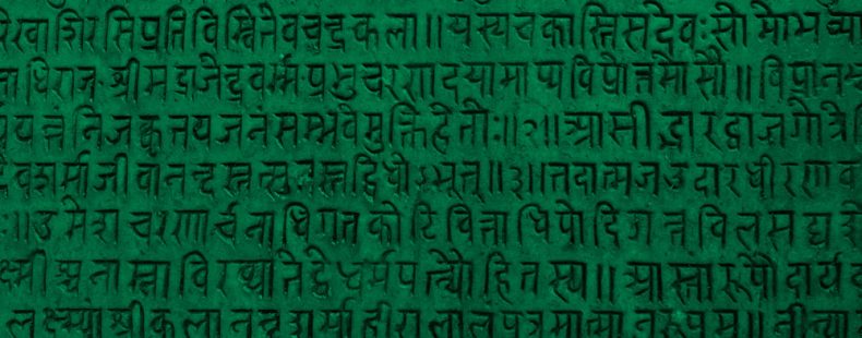 刻有古梵语文本背景一个石碑,绿色的过滤器。